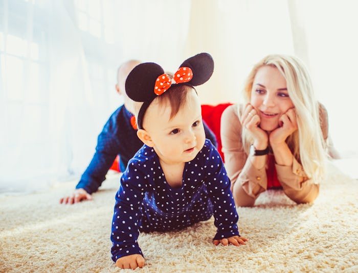 baby crawling on the floor wearing Minnie Mouse ears