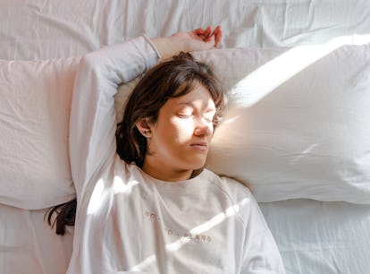 Why do I sleep with my arms above my head? Experts explain.