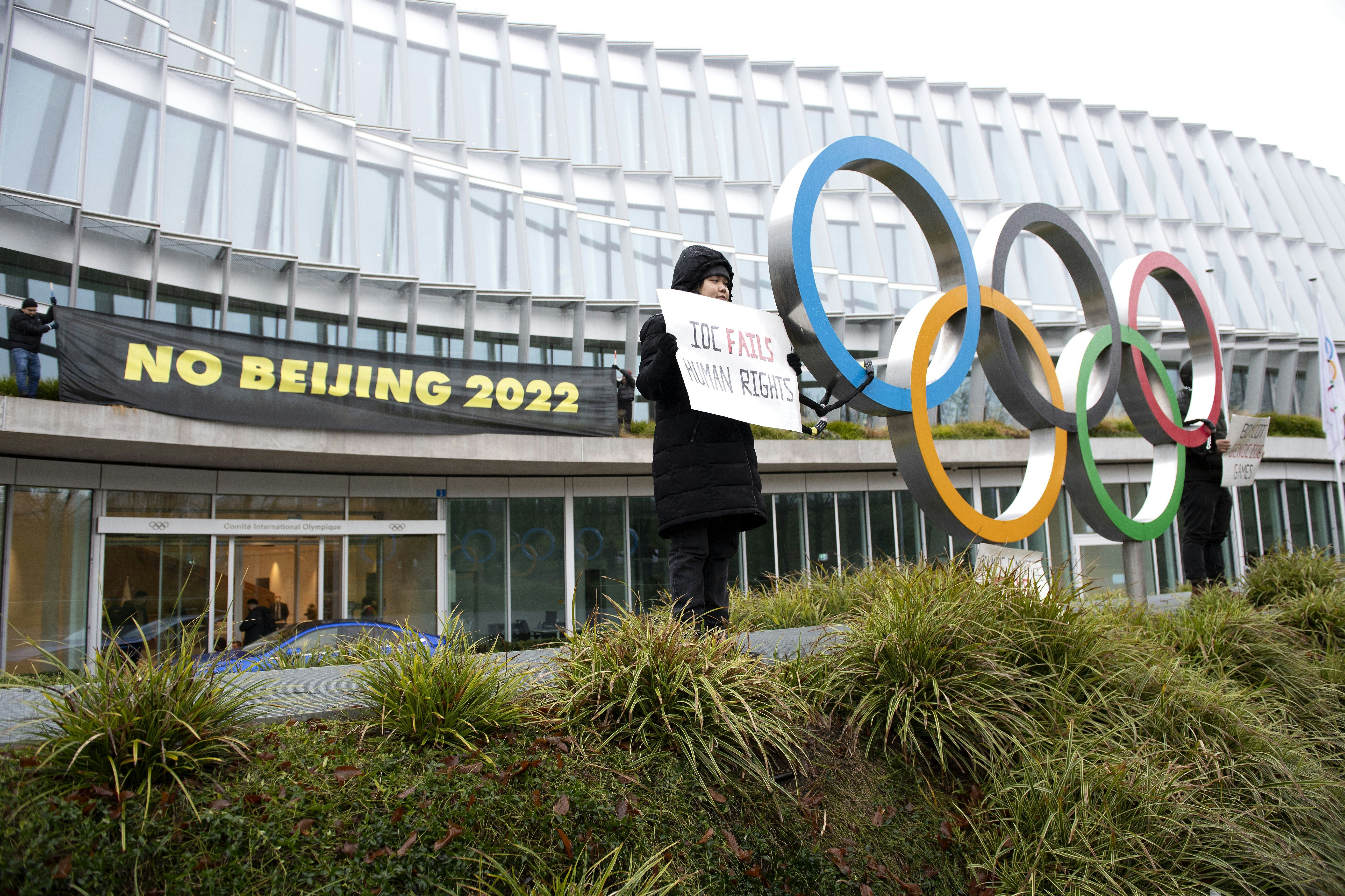 Protesters hold placards during a protest against Beijing 2022 Winter Olympics by activists of the T...