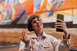 A woman wearing sunglasses is taking a selfie in front of a colorful wall. Leo's biggest weaknesses ...