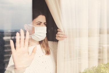 Young woman in medical mask stay isolation at home for self quarantine. Concept home quarantine, pre...