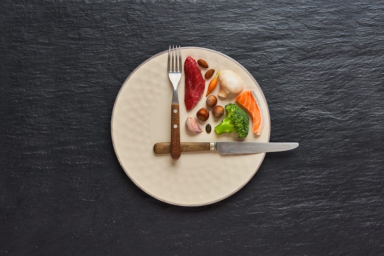  20:4 fasting diet concept. One third plate with healthy food and two third plate is empty. Beef, sa...