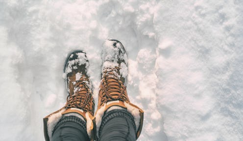 Winter hiking in Snow boots walking first person POV selfie of feet in deep cold snowfall in outdoor...