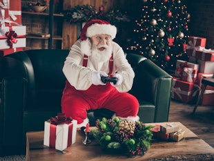 Photo of excited addicted grey hair santa claus sit couch celebrate x-mas christmas night midnight p...