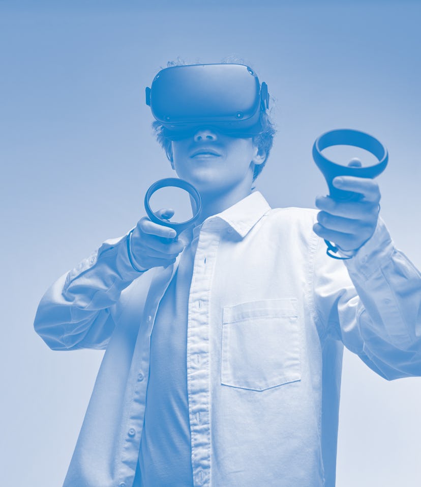 young boy play VR games in virtual reality helmets on bright colourful background, hold controllers ...