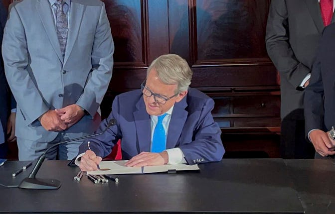Ohio Governor Mike DeWine signs an executive order allowing college athletes in Ohio to earn money o...