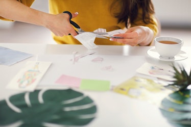 Young brunette woman creating her vision board during a vision board party is one option for nye gam...