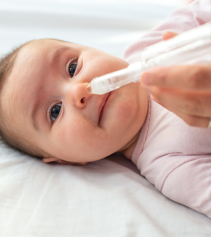 Mother using baby nasal aspirator mucus nose suction