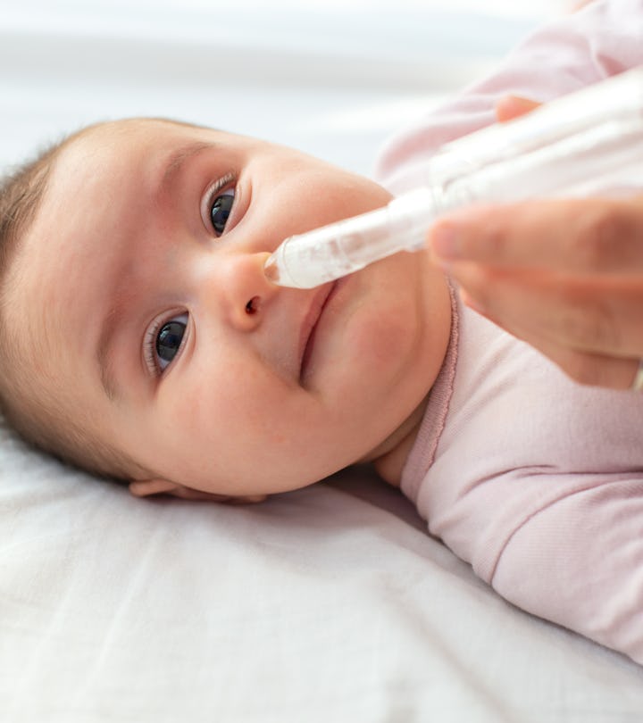 Mother using baby nasal aspirator mucus nose suction