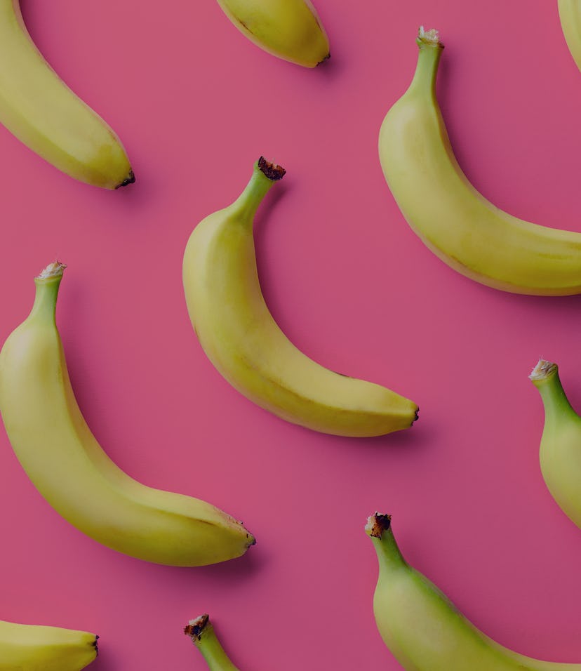 Colorful fruit pattern of fresh yellow bananas on pink background. From top view