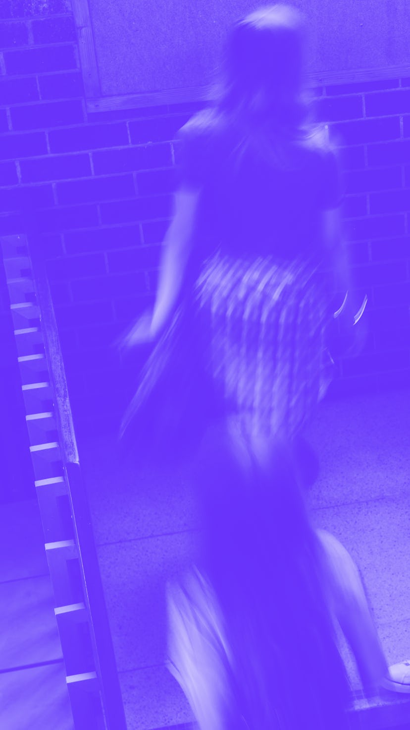 Young man standing on the staircase in college with girls walking by. Students on steps of college c...