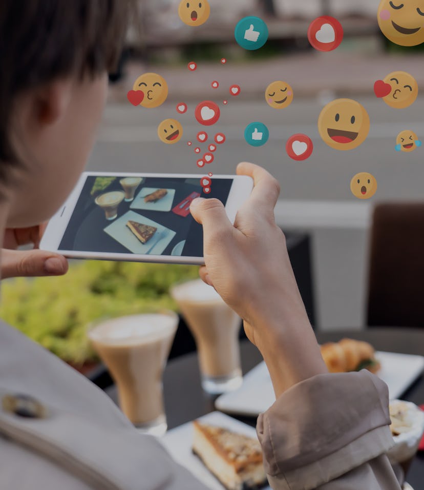 Female blogger influencer hold phone take food mobile photo on phone sit at cafe table. Girl vlogger...