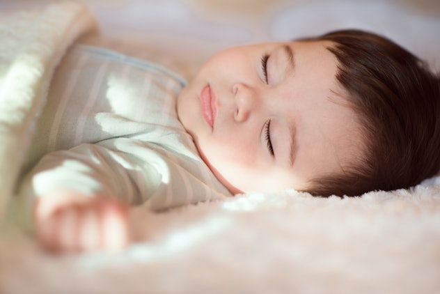 Closeup portrait of sleeping baby covered with knitted blanket. Boy names that start with J include ...