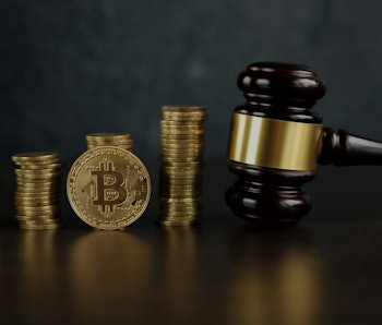 Auction gavel and bitcoin cryptocurrency money on a wooden desk, close-up. Law Gavel and golden bitc...