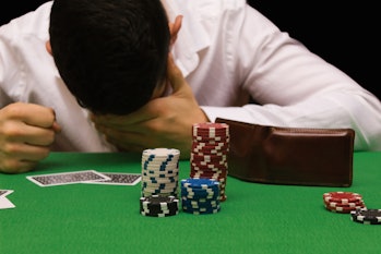 Devastated gambler man losing a lot of money playing poker in casino, gambling addiction. Divorce, l...