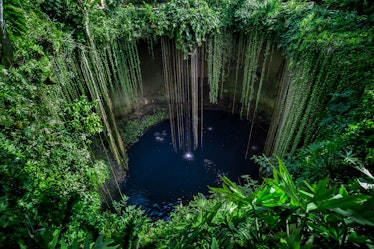 view from above of cenote ik-kil near chichen itza in Tulum, which is one of the best affordable bac...