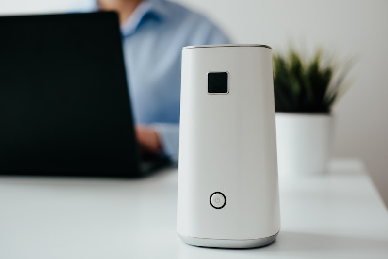 Ionizer stands on a white shelf on a white background. Air purifier at work, taking care of the comf...