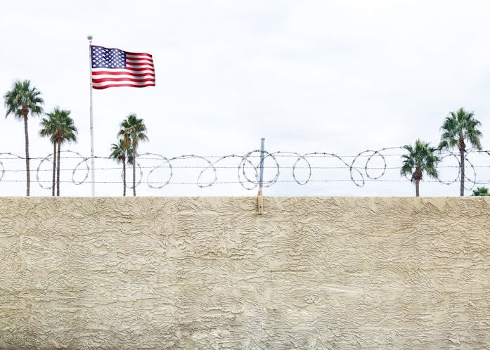 Wall with secure barbed wire fence along the southern border of the United States