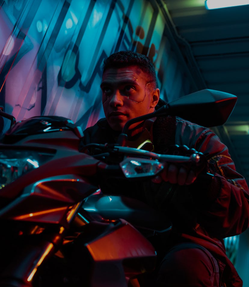 low angle view of handsome and mixed race cyberpunk player riding motorcycle