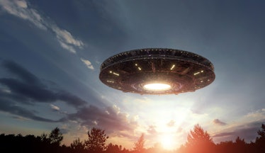 UFO, an alien plate hovering over the field, hovering motionless in the air. Unidentified flying obj...