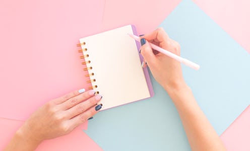 Woman's hands with perfect manicure holding pencil and spiral notepad as mockup for your design. Abs...