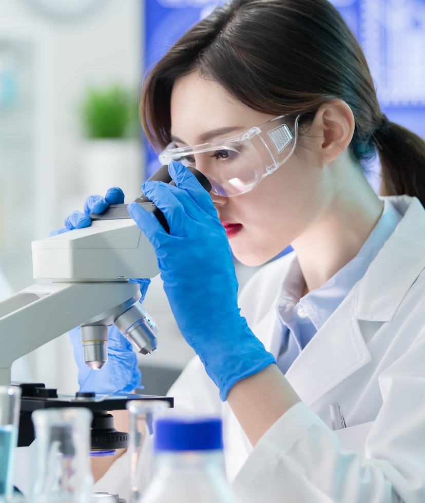 close up of asian female scientist use microscope in the laboratory