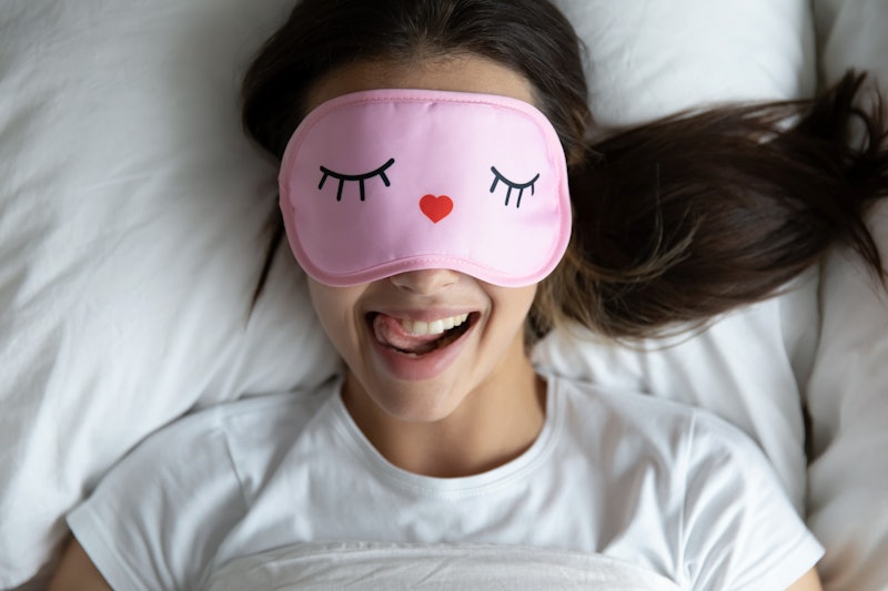 Top view portrait of happy girl lying in comfortable bed wake up in morning have fun making funny fa...