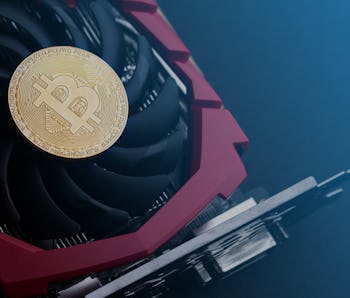 cryptocurrency mining concept with one golden bitcoin on top of a computer performant video card bla...