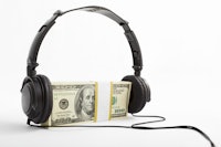 A stack of US$100 bills with headphone put on, over white background