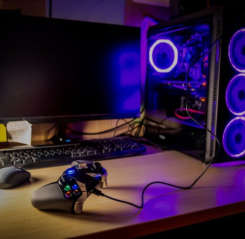 Game pad on a wooden desk with glass pc case on the background