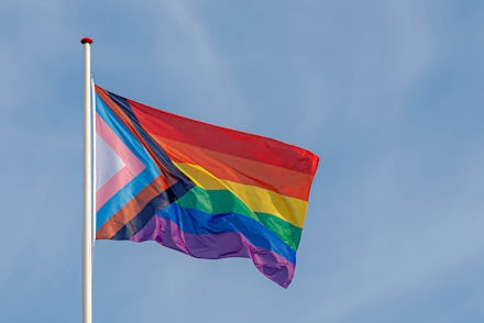 Progress pride flag (new design of rainbow flag) waving in the air with blue clear sky, Celebration ...