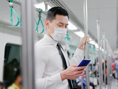 Asian business man with surgical mask face protection use a smartphone  and keep social distancing t...