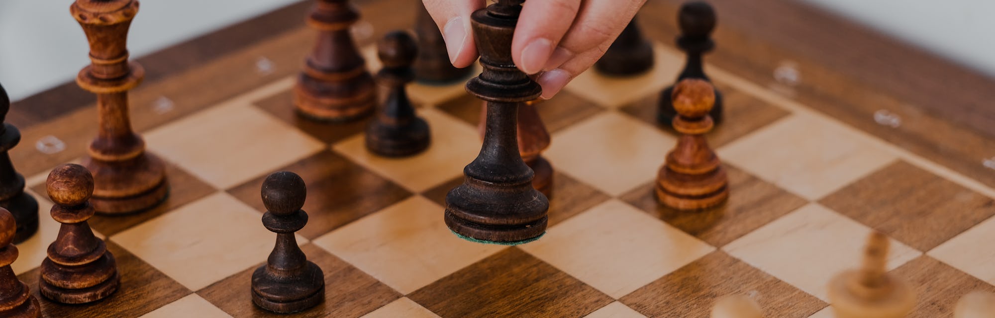 man holds a chess piece with his hand. Chess board. game of chess on a white background. chess tourn...