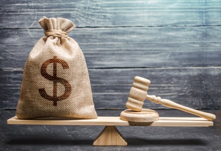 Bag of money with a dollar sign and a judge's hammer on the scales. Concept lobbying for the adoptio...