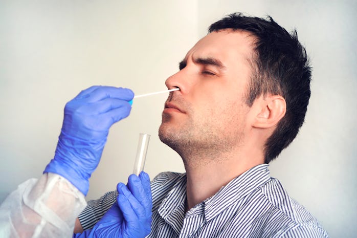 A man is seen undergoing a swab test to detect the contraction of COVID-19.