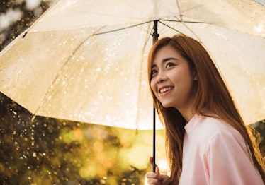 Asian woman waiting for the rain, she had an umbrella.