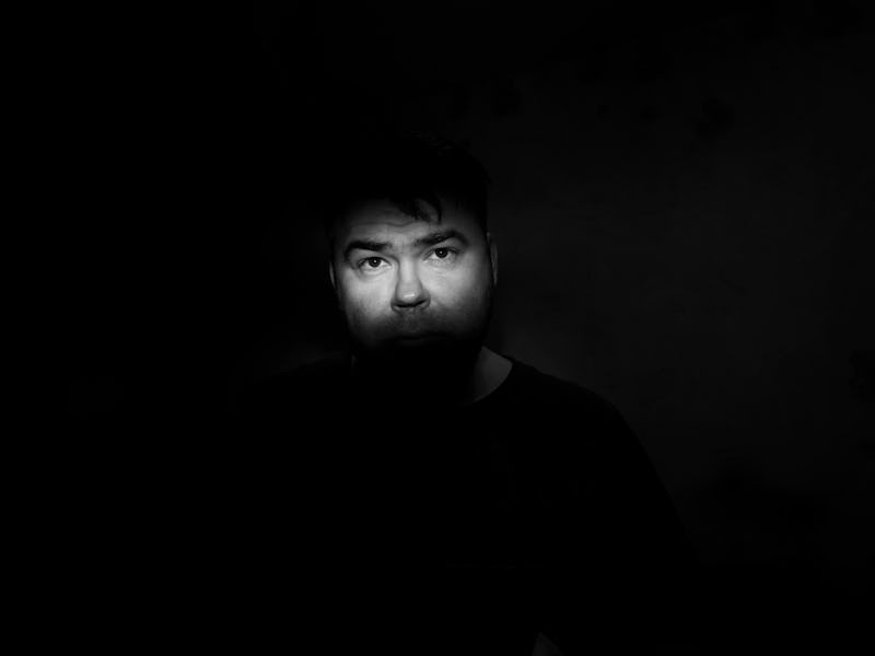 Portrait of a man with a green eye for horror or halloween. a narrow strip of light on the face, in ...
