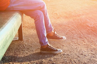 close up image of girl in sneakers sitting on the bench