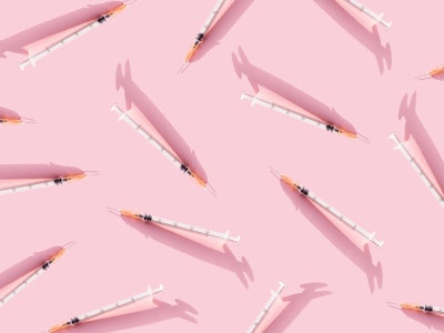 Creative medicinal pattern from syringes of pink background. Colorful concept of New Corona virus 20...