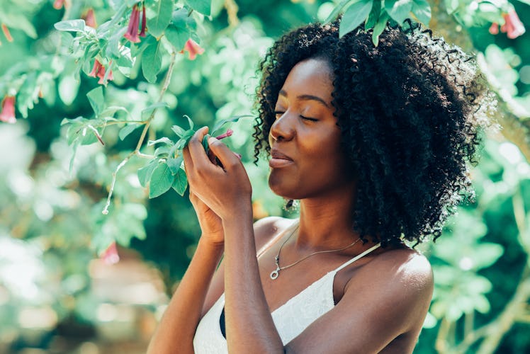 Content Black Woman Smelling Flowers in Park