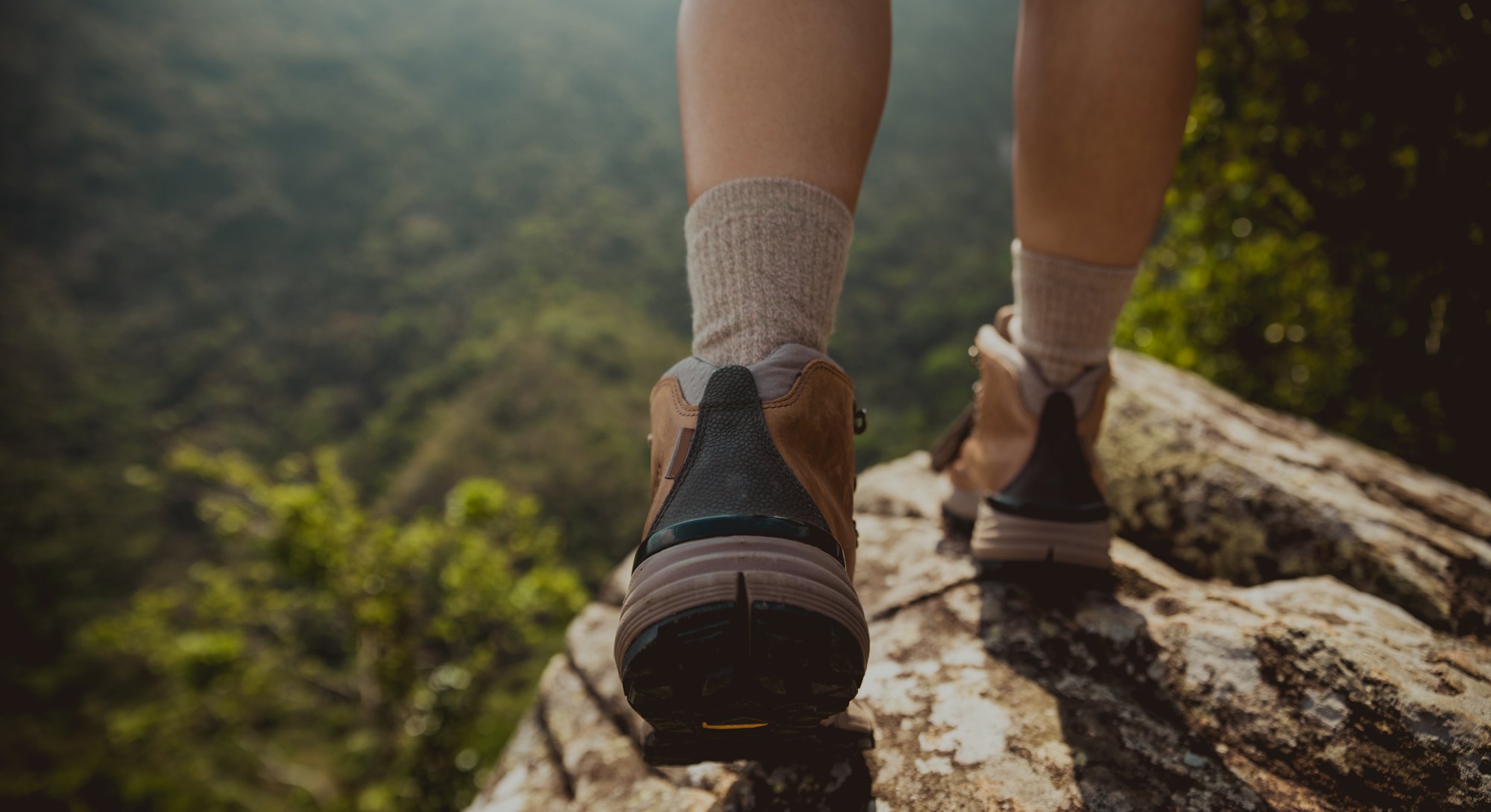 Successful hiker enjoy the view on mountain top cliff edge