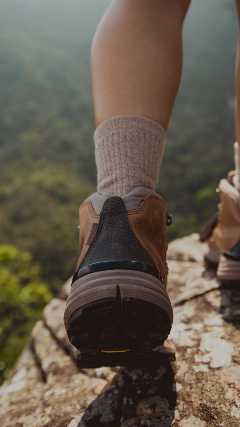 Successful hiker enjoy the view on mountain top cliff edge