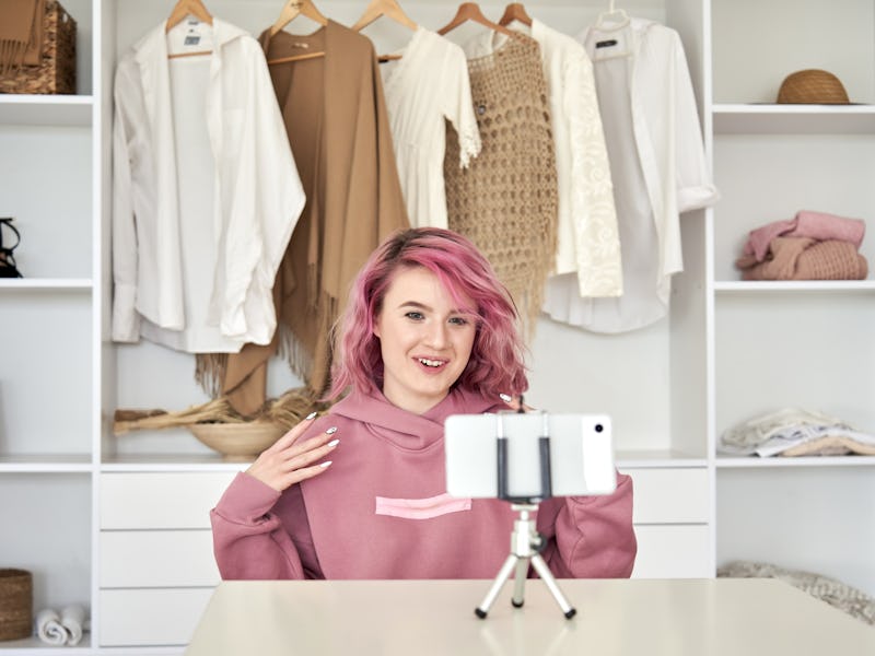 Happy hipster gen z woman fashion social media channel blogger with pink hair wear hoodie speaking r...