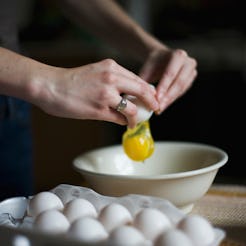Woman cracks egg into bowl