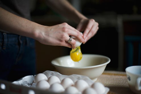 Woman cracks egg into bowl