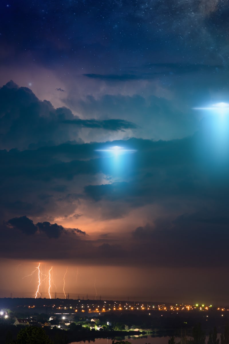 Amazing fantastic background - extraterrestrial aliens spaceship fly above small town, ufo with blue...