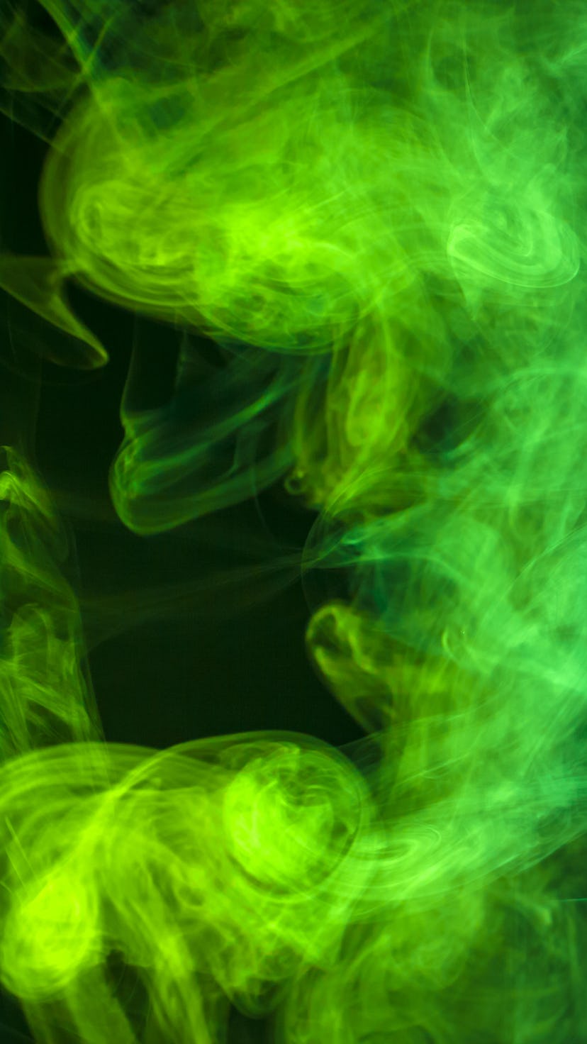 Blue and green  cloud of smoke of  black isolated background. Background from the smoke of vape
