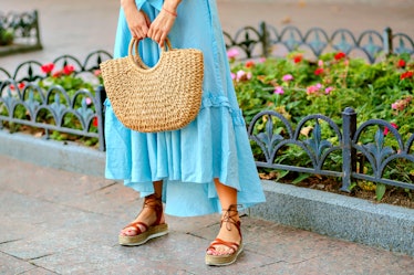 Close up fashion street details of tender stylish woman posing at Europe city, wearing blue maxi dre...