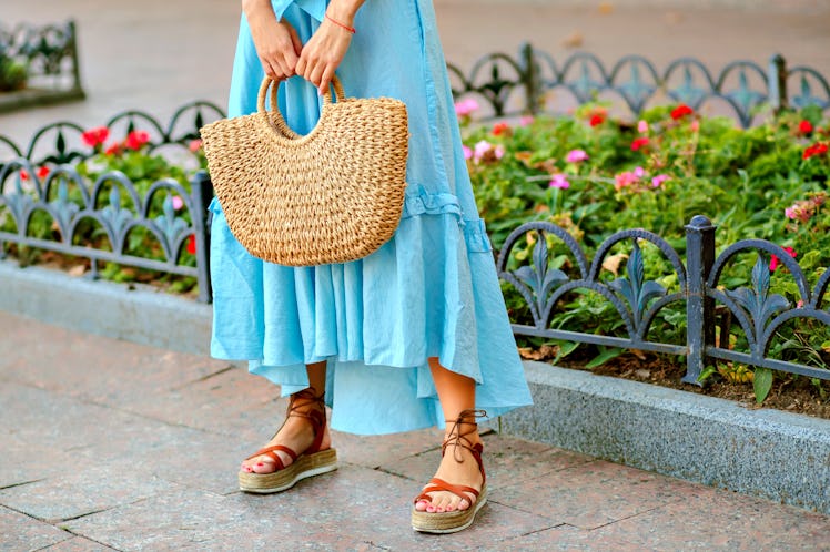 Close up fashion street details of tender stylish woman posing at Europe city, wearing blue maxi dre...