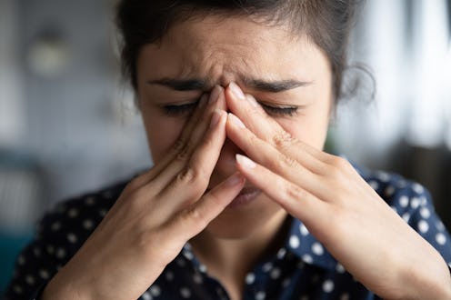 Sick frustrated sad young indian woman in pain cope with headache, eye strain emotional mental stres...